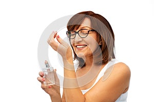 Senior woman smelling perfume from her wrist