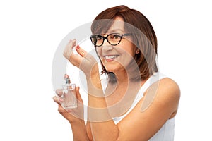 Senior woman smelling perfume from her wrist