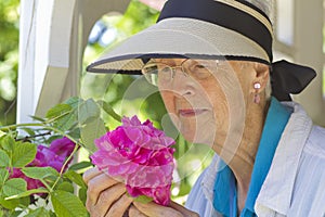 Senior woman smelling roses.