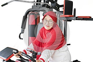 Senior woman smiling at camera on exercise bike