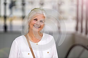 Senior woman smiling in the city