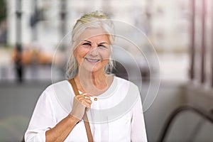 Senior woman smiling in the city
