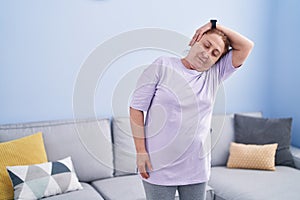 Senior woman smiling confident stretching head at home