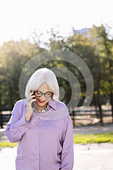 senior woman smiling happy talking by mobile phone