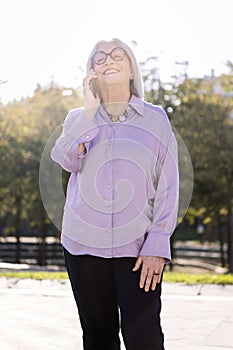 senior woman smiling happy talking by mobile phone