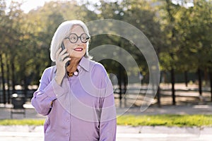senior woman smiling happy talking by mobile phone