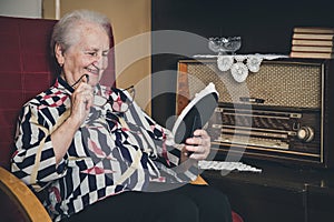 Senior woman smiling and looking at old photo frame