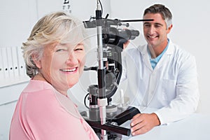 Senior woman smiling while sitting with optician