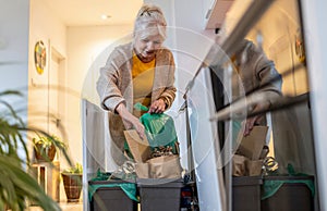 Senior woman sorting garbage in recycling bins