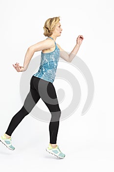 Senior Woman Sport Ideas. Running Fitness Mature Sportswoman During Active Jogging Training Against White