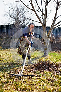 Senior woman spring cleaning in a walnut orchard