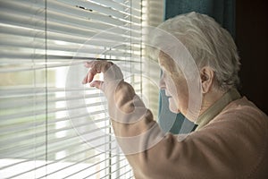 Senior woman spying through window