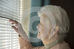 Senior woman spying through window