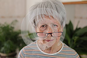 Senior woman squinting and putting her eyeglasses down