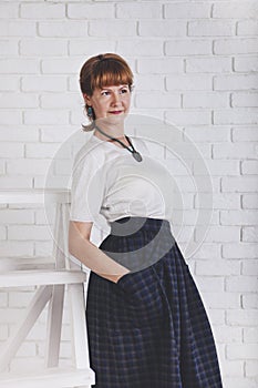 Senior woman standing against white wall