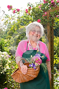 Senior woman standing with basket in garden