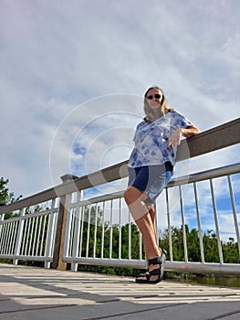 Senior woman standing beside bridge railing