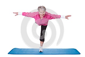 Senior woman standing on one leg and exercising photo