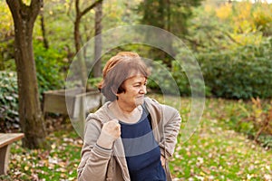 Senior woman standing in the park in autumn. Healthy lifestyle concept