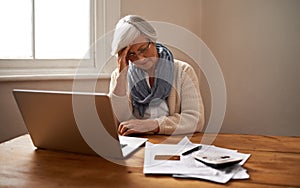 Senior woman, stress and laptop for bankruptcy in home, worry and paperwork for tax return or insurance. Elderly female