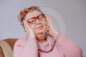 Senior Woman Stressed and Upset by Chronic Headaches at Home