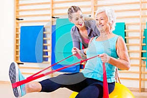 Senior woman with stretch band at fitness