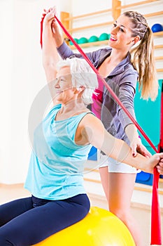 Senior woman with stretch band at fitness