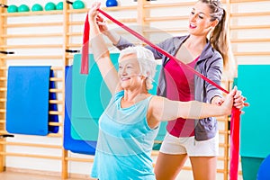 Senior woman with stretch band at fitness