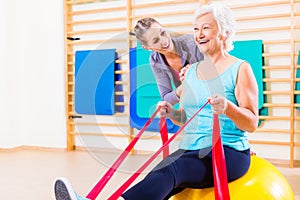 Senior woman with stretch band at fitness
