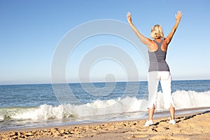 Senior Woman Stretching On Beach