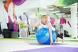 Senior woman is stretching with fitness ball