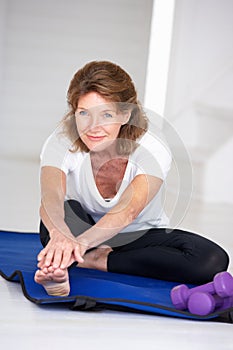 Senior woman stretching at home