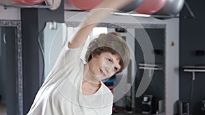 Senior woman stretching out in fitness room, mature, exercise, yoga