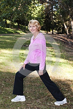 Senior woman stretching in park