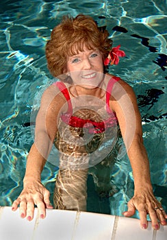 Senior woman stretching in the pool