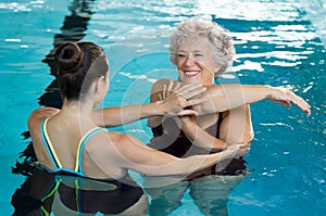 Senior woman stretching in pool