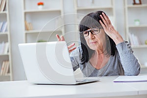 The senior woman struggling at computer