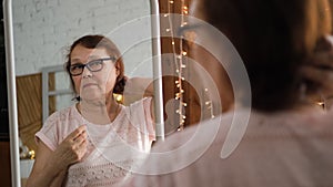 Senior Woman Styling her Hair in Front of Mirror