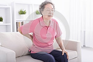 Senior woman suffering from back pain at home