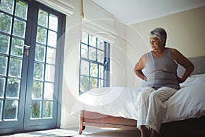 Senior woman suffering from back pain at home