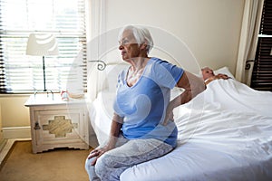 Senior woman suffering from backache in the bedroom