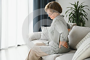 Senior woman suffering from backache at home