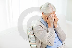 Senior woman suffering from headache or grief