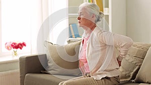 Senior woman suffering from pain in back at home