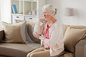 Senior woman suffering from pain in hand at home