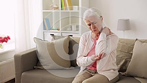 Senior woman suffering from pain in hand at home