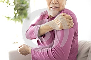 Senior woman suffers from shoulder joint pain, shoulder stiffness or osteoporosis