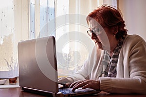 Senior woman surfing the net, reading e-mail or news online and browsing social medi