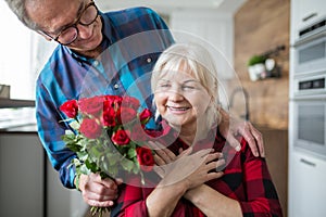 Senior woman surprised by her husband with roses