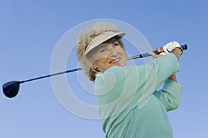 Senior Woman Swinging A Golf Club